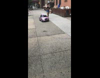 Lady controls pink toy car with baby inside it Part 1 