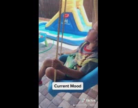 Boy sleeps on swing in backyard