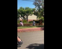 Kid dances while woman films middle street