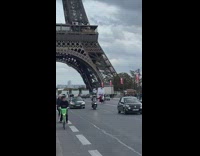 Woman poses in the middle of the street with the Eiffel Tower behind
