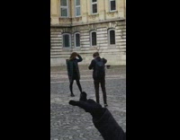 Woman in black jacket coat poses in the middle of the park
