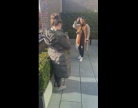 Woman with brown orange scarf poses at the bushes