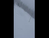 Snowboarder falls into snow from rock 