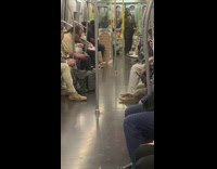 Guy on subway train dancing on pole to music from speaker