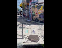 Man wearing metal helmet putting own poster on wall pt 2