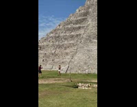 Woman in dress walks in front of pyramid