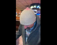 Man wearing knitted beanie that looks like breast