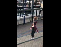 Woman red jacket dance practice near pier 