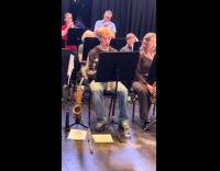 Guy enjoys playing saxophone while foot dancing