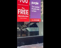 Person sleeping on bed display at mattress store 