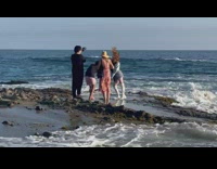 Woman shiny coat white boots flips hair repeatedly