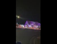 Woman tiktok dance in front of house with Christmas Decorations