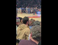 Guy takes picture hat at basketball game