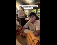 Dad opens flashlight at dim lit restaurant