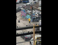 Person with spotted dog head dances in the street