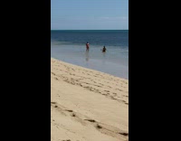 Red bikini girl friend sits beach water