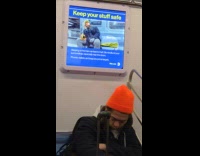Man holds luggage while sleeping in subway