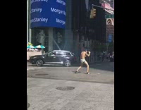 Man in diaper punches and fights alone in middle of street holding a banana