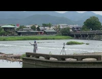 Man in stripes top and hat dance faces the river