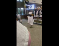 Toddler graduation in white cap and gown 