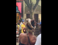 Woman on street has pet snake on head