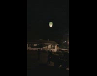 Family shooting fireworks let go on lantern get stuck in tree