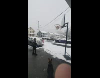 Basketball gets stuck in net on snowy day 
