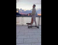 Man walking cat while on electric skateboard