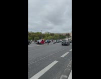 People pose and line up in the street with Eiffel Tower behind