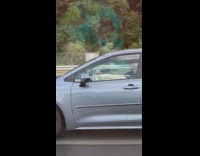 Guy driving blue car talks to camera 