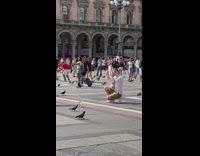 Girl red dress crowded city square birds