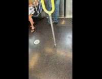 Man in grey polo does cocaine off back of his hand on the subway