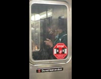 Guy smoking cigarette while standing between subway cars 
