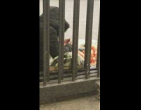 Parka Person Rolls Cigarette On Sidewalk