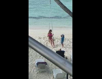 Woman pink bikini swing little kid beach