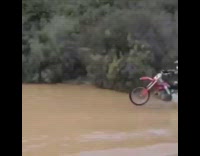 guy crashes motorcross bike in large river of mud 