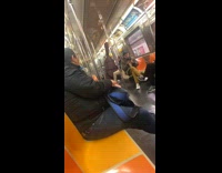 Guy on subway sitting down with a massive cello case 
