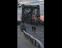 Guy black shirt stand  bridge entrance metal