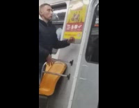 Drunk guy on subway train falls down into his seat and looks dazed