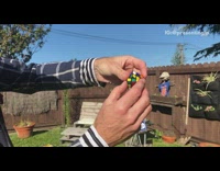 Guy juggles and solves rubiks cubes backyard 
