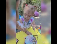 Dinosaur dress little girl grabs birthday cake 