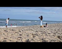 Couple beach photoshoot with their daughter nearby
