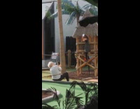 Girl hangs on a hut while mother takes picture