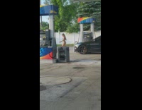 Woman in blue bikini poses at the gasoline station