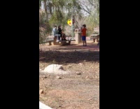 Two guys sit on park bench dance