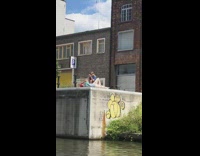 Woman hold hat lay on ledge canal