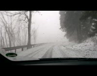 Winter drive on the snowy and foggy road