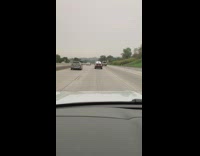 Black car two surfboards on roof freeway