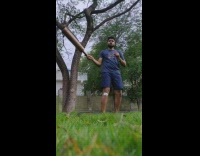 Man juggle large wooden club at yard