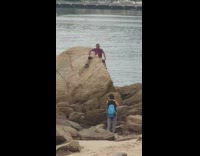 striped shirt sits on rock water